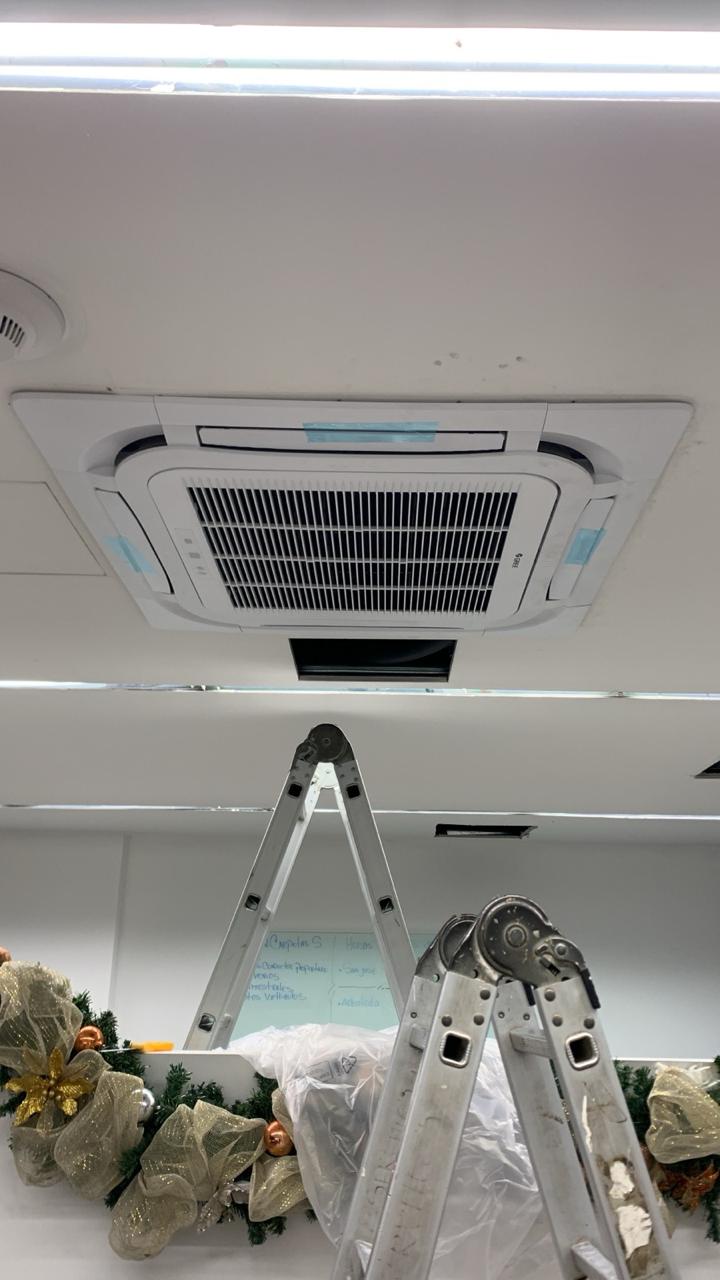Técnicos instalando sistema de climatización en techo de edificio comercial